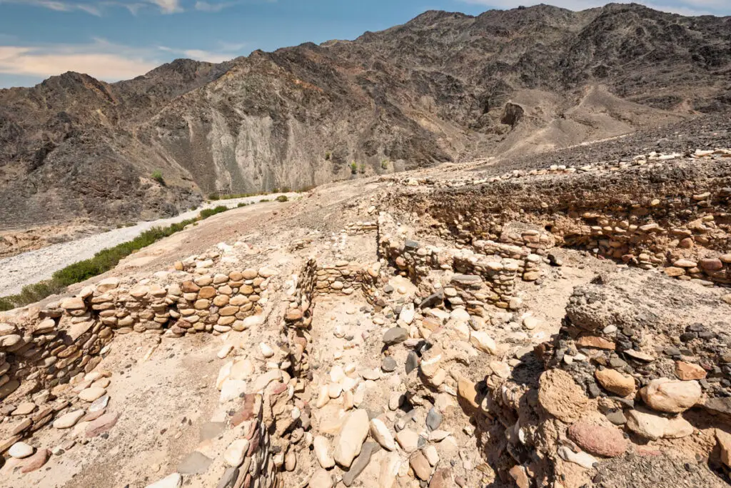 Ruins of the Ghwayr Neolithic settlement above the green wadi below, Faynan, Jordan