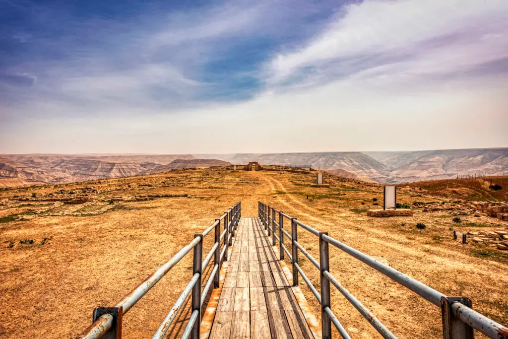 Wooden boardwalk with railings leading across Al-Lahun toward Wadi al-Mujib, Jordan