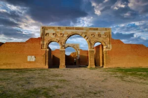 The re-erected triple arch of the throne-room block under dramatic clouds, Qasr Al-Mushatta, Jordan