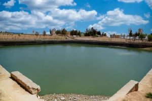 The restored Umayyad reservoir full of water under a blue sky, Qasr Al-Muwaqqar, Jordan