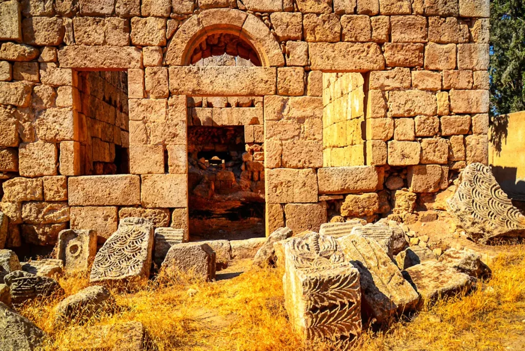 An arched niche and doorways in the palace wall with carved stones in front, Qasr Al-Qastal, Jordan