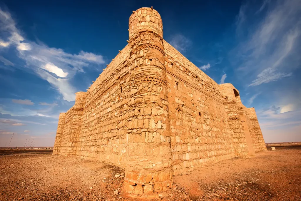 Looking up at a solid rounded corner tower, Qasr Kharana, Jordan
