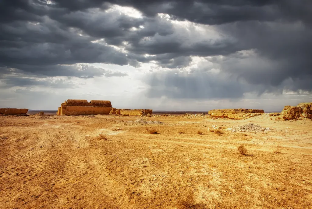 The palace small on the horizon under storm clouds, Qasr Tuba, Jordan